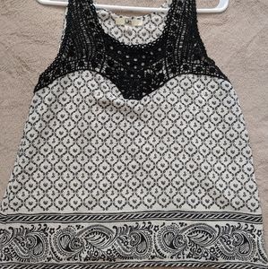 A black and white, lace trim sleeveless blouse.